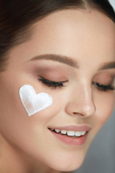 Beautiful Happy Woman With Heart Of Cream On Beauty Face Skin - Foto, immagini