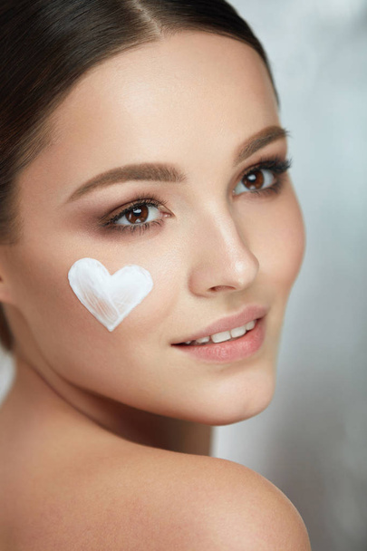 Beautiful Happy Woman With Heart Of Cream On Beauty Face Skin - 写真・画像