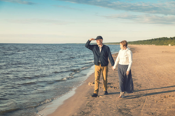 пожилая пара с романтической прогулкой по пляжу на закате
 - Фото, изображение