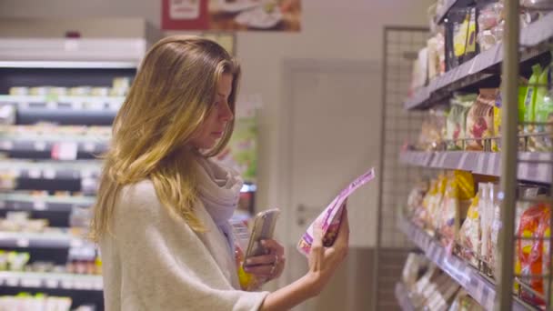 Młoda atrakcyjna kobieta w supermarkecie - Materiał filmowy, wideo