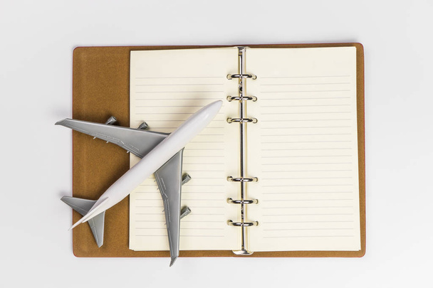 Avión de juguete en cuaderno en blanco para el concepto de diario de viaje
 - Foto, Imagen