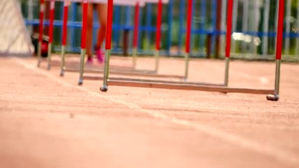 Sportovkyně cvičí překážkový běh na základě sportovní pevné sportovní přípravy v horkém letním dni - Záběry, video