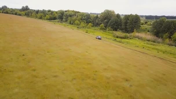 Antenne. über dem Geländewagen fliegen, der schnell im Gelände durch ländliche Gegenden fährt - Filmmaterial, Video