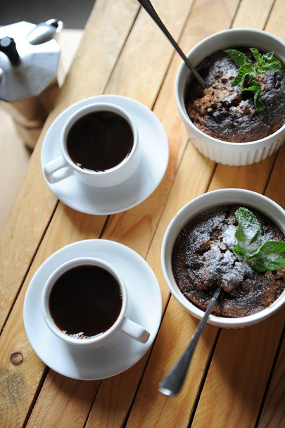 Postre desayuno saludable de pudín de avena en un molde keraimic blanco. Café Moka en tazas blancas
 - Foto, imagen