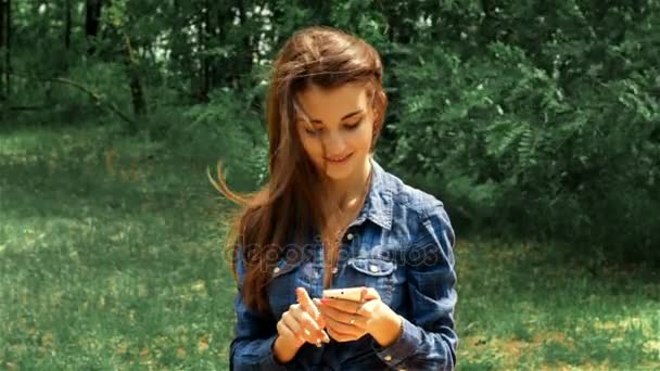 beautiful brunette sitting on the street and look in the phone - Séquence, vidéo