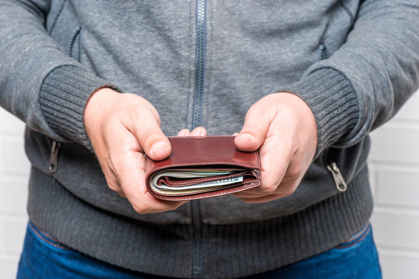 男はお金で彼の財布を保持する手のクローズ アップ - 写真・画像