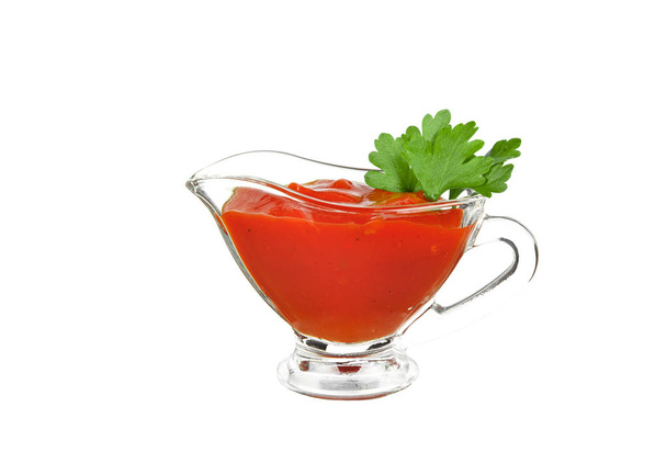 Glass sauceboat with red tomato ketchup and green parsley leafs - Photo, Image