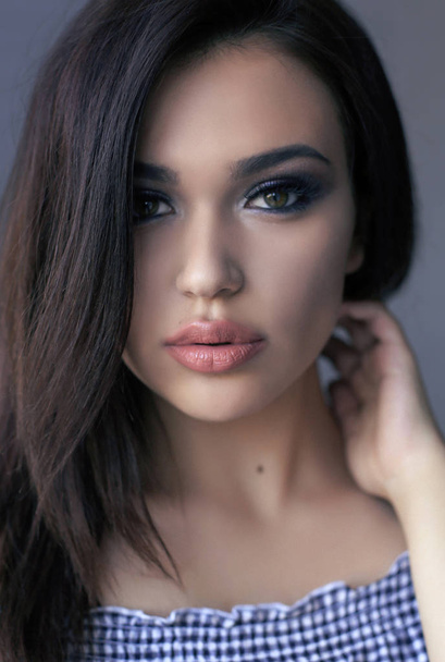 beautiful girl with dark hair and evening makeup posing at studi - Fotoğraf, Görsel