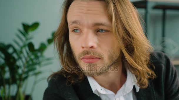 Portrait of long hair businessman looking kindly at the camera. Smiling young man portrait at office. Close up - 映像、動画