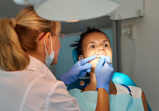 Krásná žena zubař léčbě pacientů zubů v zubní vypnuto - Fotografie, Obrázek