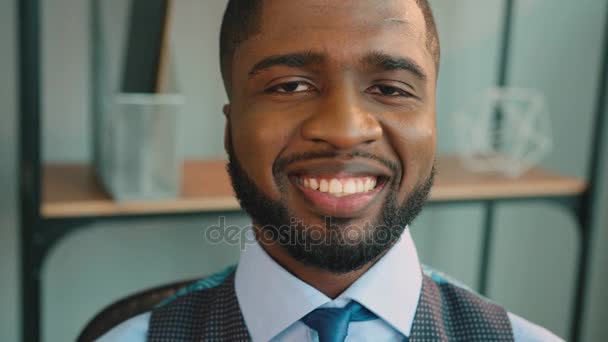 Close up of smiling african american businessman looking at the camera and smiling. Black man at the office - Materiał filmowy, wideo