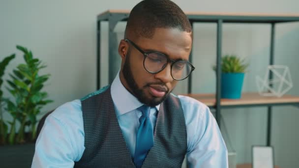Handsome African American business man working in the office and looking at the camera. Portrait of smiling office worker. - Materiał filmowy, wideo