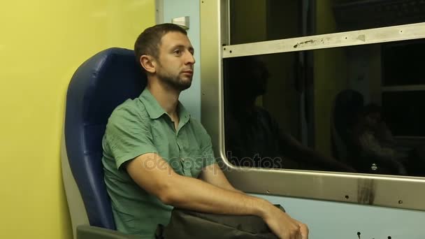 Εξαντληθεί αρσενικό ταξιδιώτης κάθεται στο κάθισμά του, πηγαίνοντας σε άλλη πόλη από νυχτερινό τρένο - Πλάνα, βίντεο