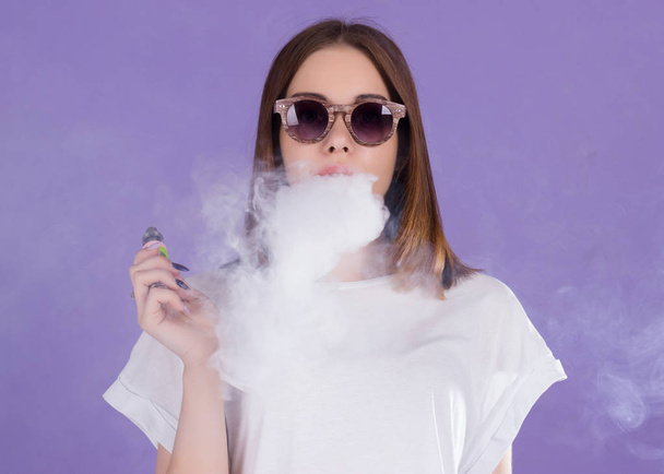 Young pretty girl with electronic cigarette - Photo, Image