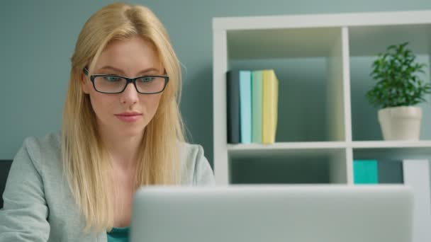 Attractive blonde businesswoman working with laptop computer at the office - Кадри, відео