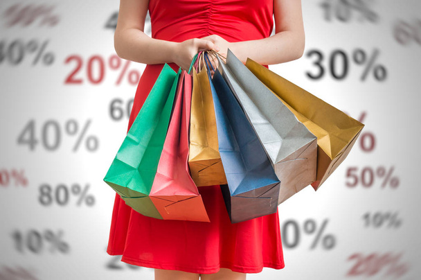 Discounts and shopping concept. Young woman holds many colorful  - Photo, Image