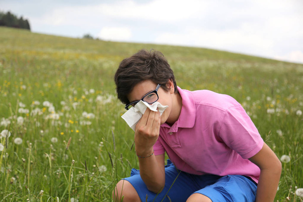 Allergique garçon avec des lunettes lui souffle le nez
 - Photo, image