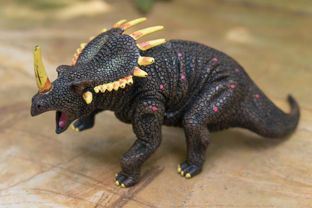 graues Triceratops-Spielzeug steht auf Felsen - Foto, Bild