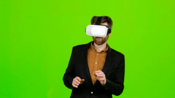 Guy in the virtual glasses is watching an interesting movie. Green screen - Záběry, video