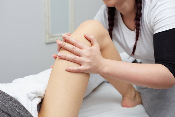 Therapist applying pressure on female leg - Fotoğraf, Görsel
