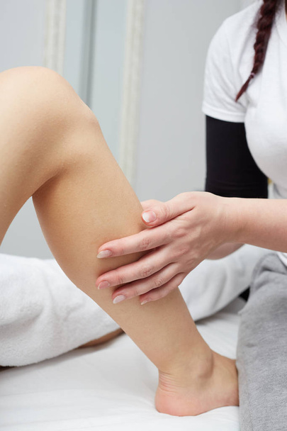 Terapeuta aplicando pressão na perna feminina
 - Foto, Imagem