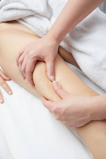 Therapist applying pressure on female leg - Фото, изображение