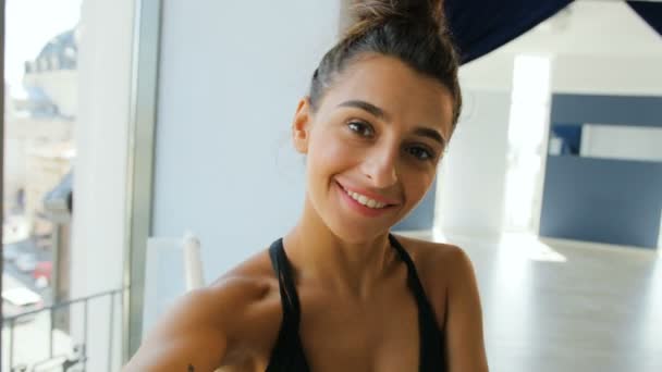 Portrait of attractive woman standing near ballet barre and making selfie on camera, smiling and possing. - Imágenes, Vídeo