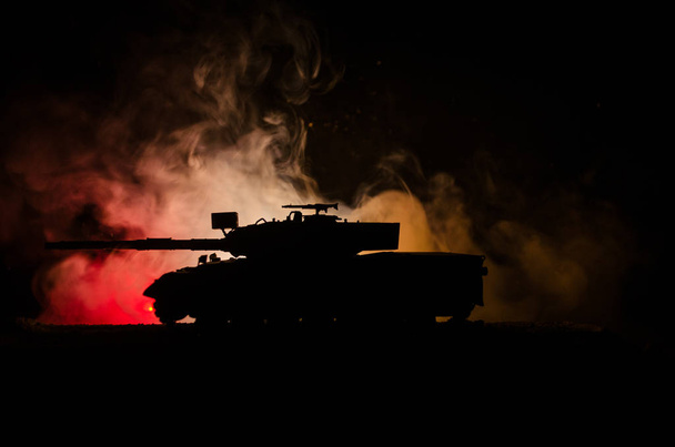 War Concept. Military silhouettes fighting scene on war fog sky background, German tank in action Below Cloudy Skyline At night. Attack scene. Armored vehicles - Photo, Image