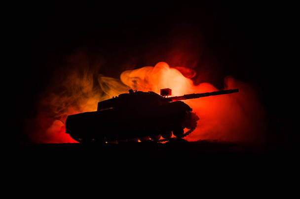 戦争の概念。戦闘シーン戦争戦車アクション以下曇りスカイライン夜の霧空の背景に軍事のシルエット。攻撃シーン。装甲車両 - 写真・画像