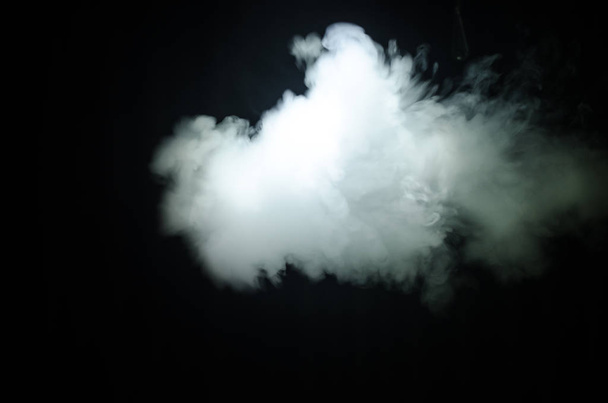 Dampfender Mann mit einem Mod. eine Dampfwolke. schwarzer Hintergrund. Verdampfen einer elektronischen Zigarette mit viel Rauch - Foto, Bild