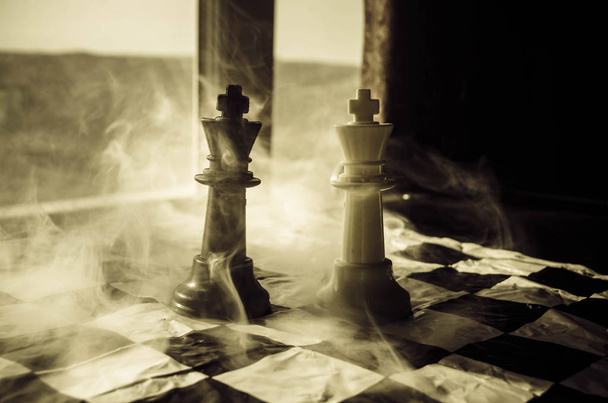шахи настільної гри концепція бізнес-ідей та конкурсу та стратегія ідеї concep. Шахові фігури на темному тлі з димом і туман і вікно з сонячного світла. - Фото, зображення