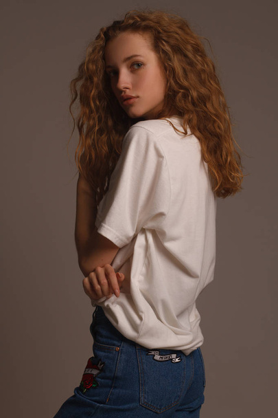 Πορτρέτο του όμορφη κοπέλα σε στούντιο με σγουρά μαλλιά - Φωτογραφία, εικόνα