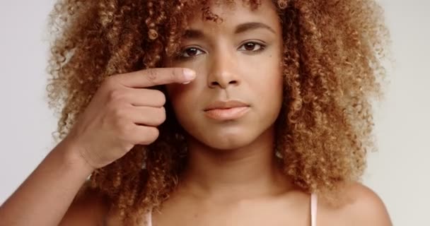 black mixed race blondie woman puts cream on cheeks like a baseball player and laughing then - Filmagem, Vídeo