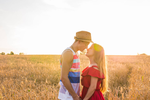 Jeune couple d'amour embrasser sur le terrain dans la lumière du soleil
 - Photo, image