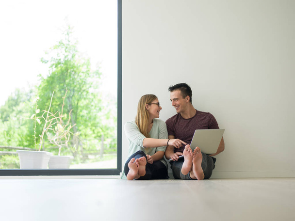 couple using laptop on the floor at home - Foto, Imagem
