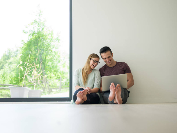 couple using laptop on the floor at home - Foto, imagen