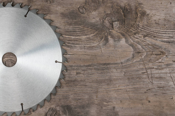 Circular saw lies on a wooden surface. - 写真・画像