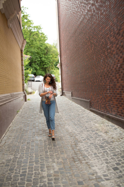 View on travelgirl walking in narrow street. - Фото, изображение