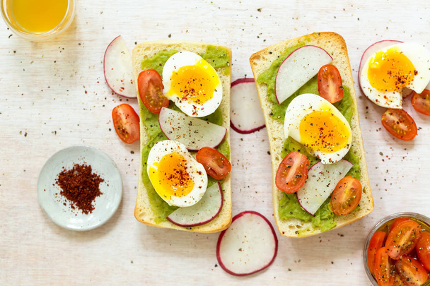 Avocado toast with eggs and tomatos - Foto, Bild