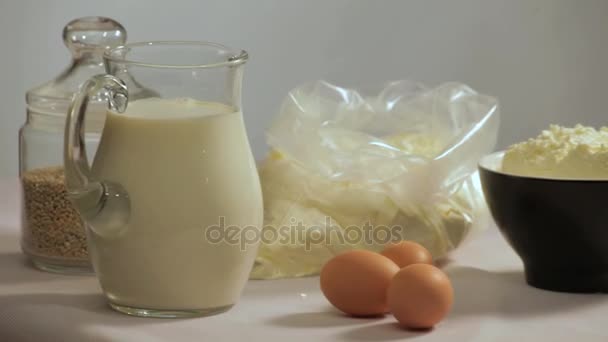 Tej és tojás asztalra. Szerves összetevőket a főzéshez. Összetevők sütés - Felvétel, videó