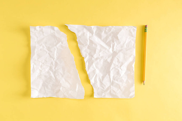 Torn piece of paper and a pencil on yellow - Fotó, kép