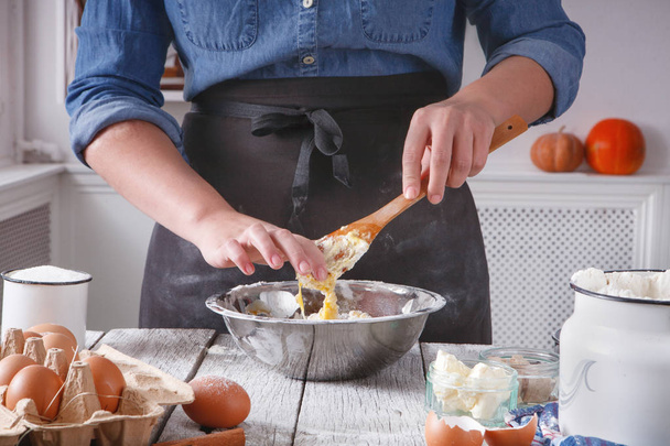 Woman baker stir dough with eggs, butter and flour - Zdjęcie, obraz