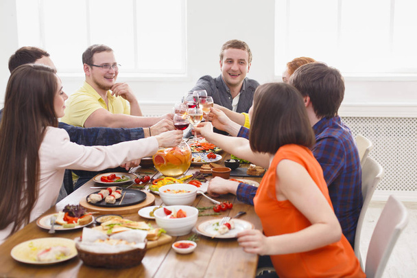 Mensen zeggen cheers clink bril op feestelijke tabel diner - Foto, afbeelding