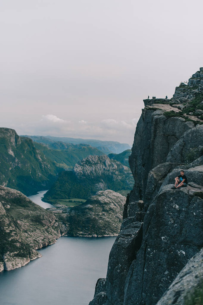 Guy on the edge of the prelude to Preikestolen Norway - Фото, изображение