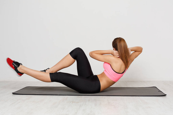 Figurka leżącej kobiety fitness robi crunches - Zdjęcie, obraz