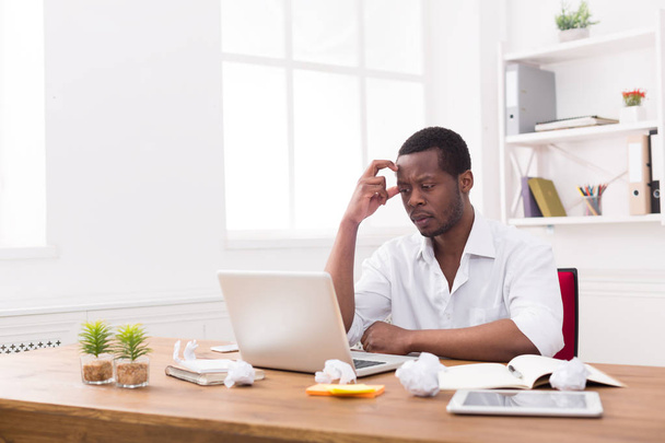 Impiegato africano-americano stanco in carica, lavoro con il computer portatile
 - Foto, immagini