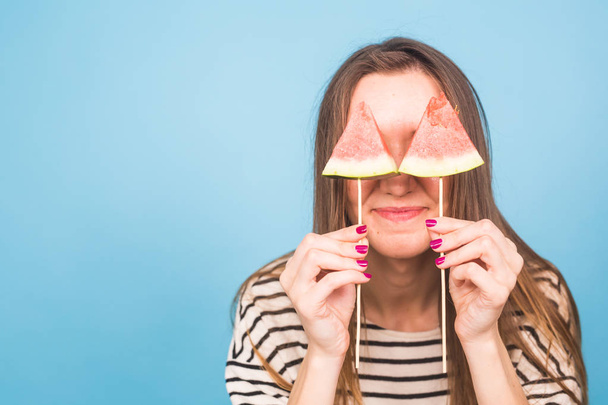 Summer, vacation, diet and vegans concept - Beautiful smiling young woman holding watermelon slice on stick - Foto, afbeelding