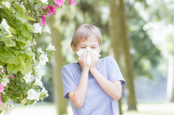 Allergia. Gyerek orrát a selyempapír fúj a parkban - Fotó, kép