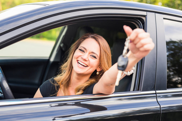 Young woman getting her key in the car. Concept of rent car or buying car - Photo, Image