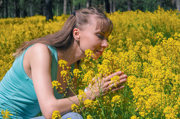 Allergic reactions to spring flowers, pollen, ragweed. Seasonal allergy. Woman blowing her nose in background spring park. - Photo, Image